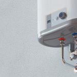 Water heater with control panel and red-blue fittings, showcased by Maxwell-White Plumbing for maintenance tips.