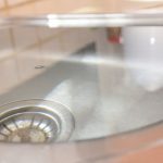 Sink with clear water and metallic drain, symbolizing plumbing solutions by Maxwell-White Plumbing.