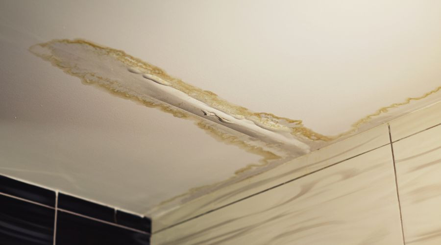 Ceiling with water damage, stains, and cracks, indicating plumbing issues for Maxwell-White Plumbing services.