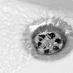 Drain with flowing water, illustrating plumbing maintenance and hydro jetting effectiveness for resolving clogs and buildup.